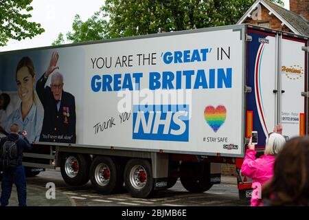 Un camión que lleva un mensaje alabando al capitán Tom y el NHS pasa a su casa en Bedford mientras celebra su centenario. Foto de stock