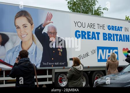 Un camión que lleva un mensaje alabando al capitán Tom y el NHS pasa a su casa en Bedford mientras celebra su centenario. Foto de stock
