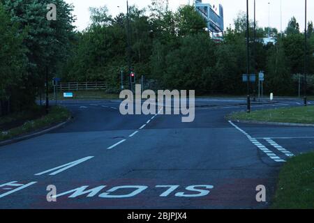 Cruce de caminos vacíos rodeado de árboles en Manchester, Inglaterra Foto de stock