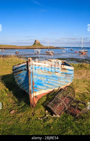 Un barco en la orilla de la Isla Santa con el Castillo de Lindisfarne en el fondo, Inglaterra Foto de stock
