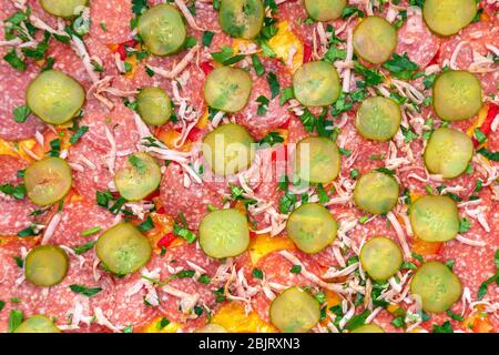 cocina pizza casera con tomates de pimienta de salchicha, queso, primer plano de salami enfoque selectivo. cableado de la cámara, comida casera Foto de stock