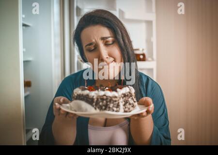 Plus Size Mujer admira pastel de chocolate Foto de stock