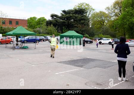 La cola pública a pie manteniendo un espacio de 2 metros esperando las pruebas de Covid-19 en un sitio móvil pop up en Rugby Warwickshire Reino Unido capturó el 1 de mayo de 2020 Foto de stock