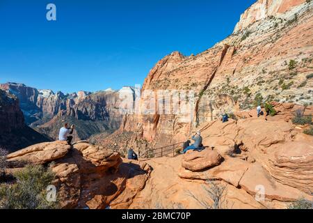 Los senderistas que miran hacia la vista del Cañón Zion desde el mirador del Cañón, el Parque Nacional Zion, Utah, Estados Unidos