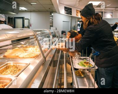 París, Francia - 9 de diciembre de 2017: Vista lateral de las compras de comida imaptient joven familia en IKEA Food Court restaurante deliciosos albóndigas suecos, ensalada y patatas fritas Foto de stock