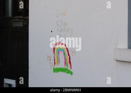 Huddersfield, Reino Unido - 4 de mayo de 2020: Un niño dibujó un arco iris en crayón en el lado de una casa en West Yorkshire.