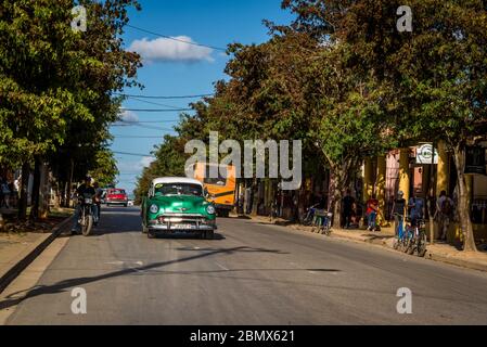 Coche de época que pasa por la carretera principal, Vinales, Cuba Foto de stock