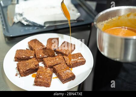 Plato blanco con trozos de brownie recién horneados Foto de stock