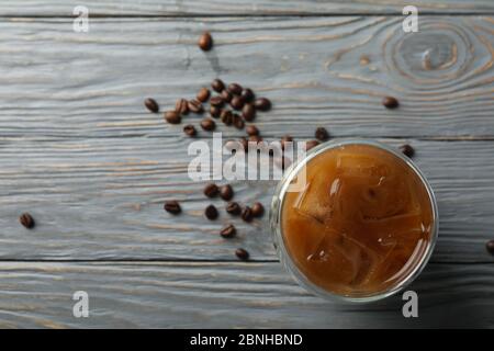 Vaso de café helado sobre fondo de madera. Semillas de café