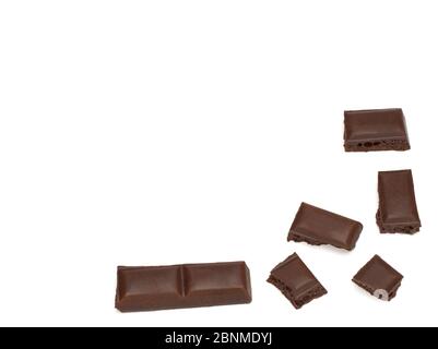 primer plano de trozos de chocolate porosos oscuros sobre fondo blanco Foto de stock