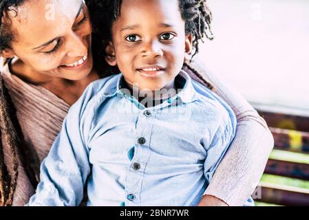 Familia amor concepto con afro negro madre y niños hijo pequeño juntos abrazando y sonriendo con felicidad - hermosa pareja momia y niño en actividades de ocio al aire libre