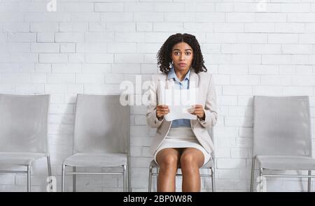 Beautuful chica negra con curriculum vitae teniendo miedo de su entrevista de empleo en el cargo. Espacio para texto