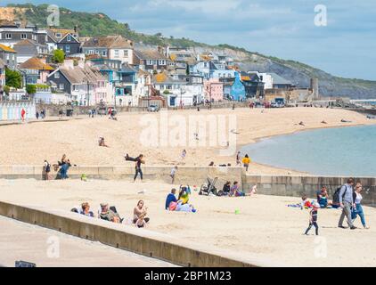 Lyme Regis, Dorset, Reino Unido. 17 de mayo de 2020. Reino Unido Clima: Los lugareños disfrutan de tiempo en la playa de Lyme Regis el primer domingo soleado desde que se aliviaron las restricciones del coronavirus del gobierno. Crédito: Celia McMahon/Alamy Live News