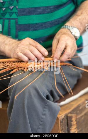 Una cesta weaver en el trabajo en la fábrica tienda en Camacha en la isla de Madeira, Portugal Foto de stock