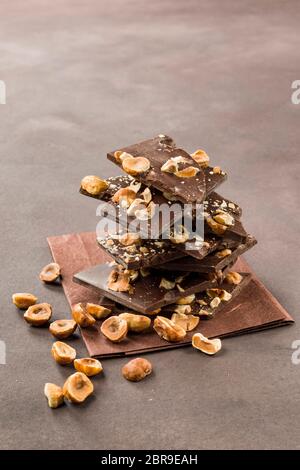 Avellana trozos de chocolate oscuro sobre fondo marrón Foto de stock