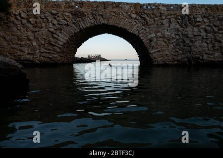 Europa, Portugal, Caiscas. Un hombre nadaba en medio del puente que delimita el Palácio dos Condes de Castro Guimarães en Caiscas.