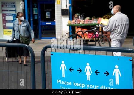 Londres Mayo de 2020 la pandemia de Covid-19. Kingsland Road, Hackney. Señal delante de la estación diciendo a la gente a distancia social. Foto de stock