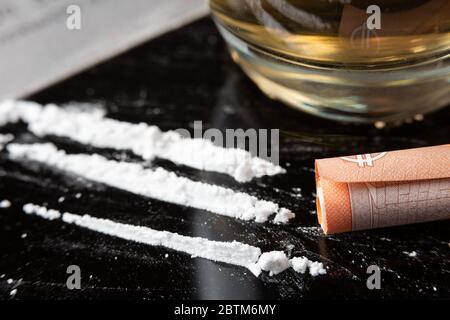 Líneas de cocaína preparadas sobre una mesa y un billete enrollado listo  para ser esnifado Fotografía de stock - Alamy