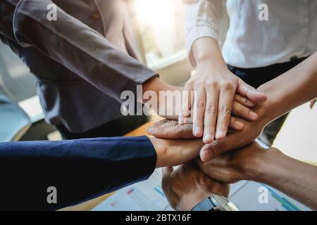 Éxito en el trabajo en equipo. Grupo de personas de negocios feliz mostrando trabajo en equipo y uniéndose a manos después de reunirse con el negocio de socios
