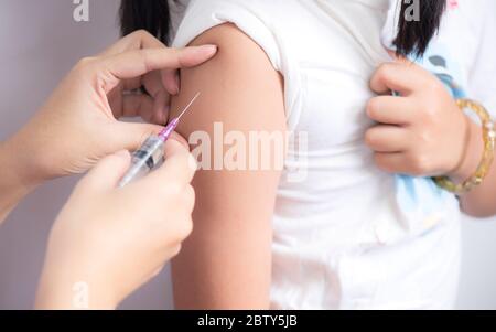 Las manos de las enfermeras están preparando inyecciones de vacunación para el niño Foto de stock
