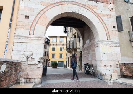 VERONA, ITALIA - 14, MARZO, 2018: Imagen de gran angular de la puerta a Ponte Pietra, un famoso puente de Verona, Italia Foto de stock