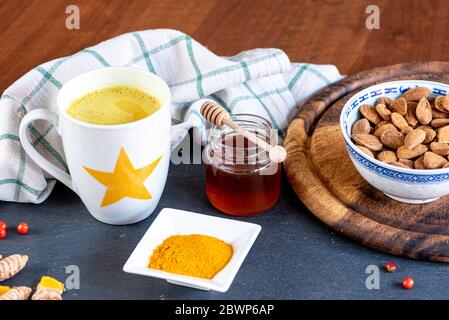 La cúrcuma té o leche de oro ha sido venerada desde la antigüedad por sus propiedades curativas. Tabla con los ingredientes Foto de stock
