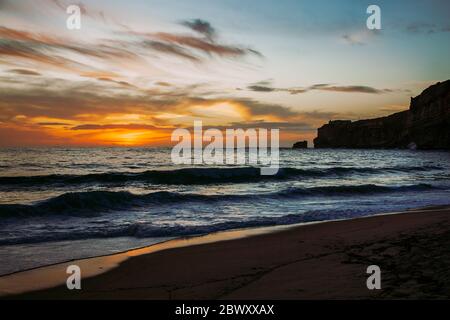Nazare, Portugal: Puesta de sol sobre el Océano Atlántico vista desde la playa Foto de stock