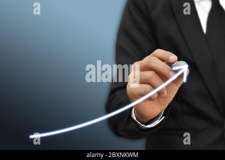 Businessman dibujando flecha en la pantalla gráfica plan corporativo de crecimiento futuro. Concepto de desarrollo y crecimiento empresarial.