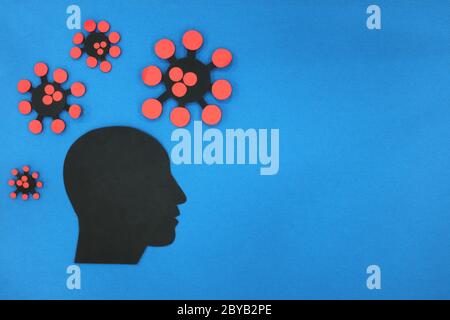 Concepto de depresión y ansiedad pandémica de la salud mental Covid-19. Perfil de cabeza humana de silueta masculina con coronavirus en fondo azul con espacio de copia.