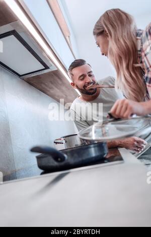El esposo y la esposa joven cocinar la cena juntos Foto de stock