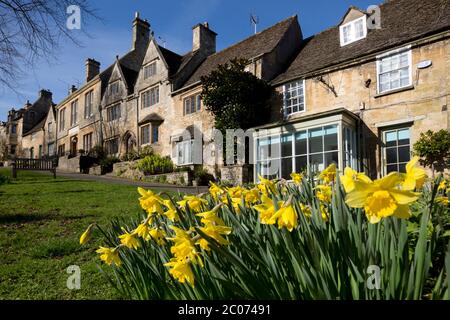Cotswold casas a lo largo de la colina con narcisos de primavera, Burford, Cotswolds, Oxfordshire, Inglaterra, Reino Unido Foto de stock