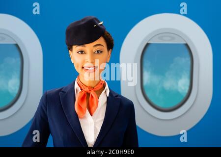 un sonriente asistente de vuelo afroamericano mirando la cámara con baches sobre fondo azul Foto de stock