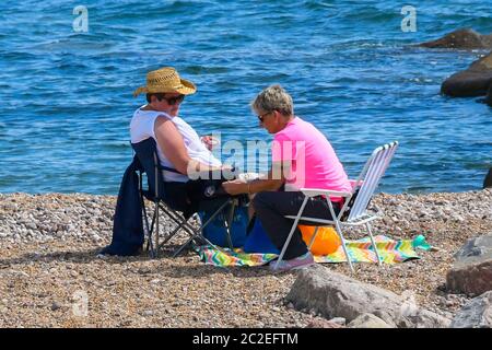 West Bay, Dorset, Reino Unido. 17 de junio de 2020. El tiempo en el Reino Unido. Los visitantes disfrutan del sol caliente en la playa en el complejo costero de West Bay en Dorset. Crédito de la imagen: Graham Hunt/Alamy Live News Foto de stock