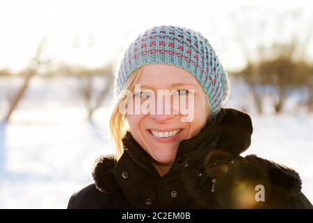 Mujer rubia caminando afuera en un paisaje nevado de invierno. El tiempo de Navidad y el concepto de desgaste de invierno.
