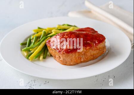 Meatloaf coronado con salsa de tomate con judías verdes Foto de stock