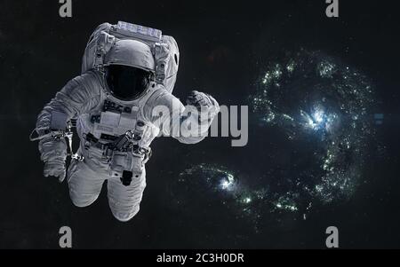 Astronauta sobre un fondo de galaxias azules en colisión. Renderización 3D Foto de stock