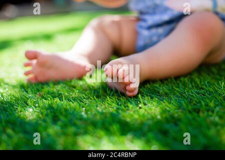 pies de bebé en verano en el césped verde, primer plano, espacio para el texto Foto de stock