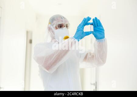 Hombre con ropa protectora y máscara de gas sobre fondo blanco Foto de stock