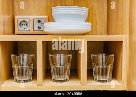 los platos se secan en un estante para los platos en el gabinete de la cocina Foto de stock