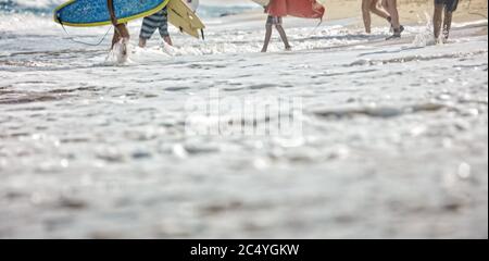 Surfistas en la playa, la costa y la gente Foto de stock
