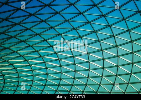 Imagen de fondo geométrico fresco de un techo de cristal y cielo azul.