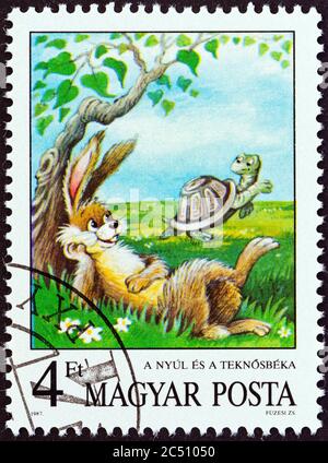 HUNGRÍA - ALREDEDOR de 1987: Un sello impreso en Hungría de la edición de 'Fairy tales' muestra la liebre y la tortuga (Aesop), alrededor de 1987. Foto de stock