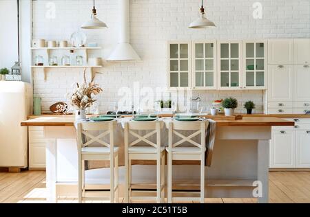 Gran isla unidad móvil sobre ruedas en la moderna cocina blanca con suelos  de piedra caliza Fotografía de stock - Alamy