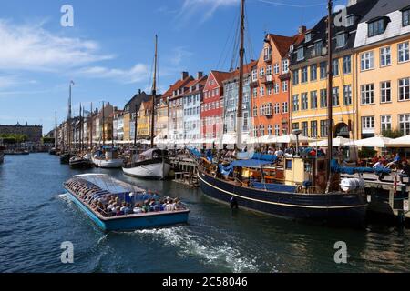 Paseo en barco por el canal Nyhavn (New Harbor) bordeado de barcos y casas de antiguos comerciantes Foto de stock