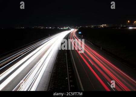 Rutas de autos ligeros que conducen desde los coches que pasan durante la noche. Foto de stock