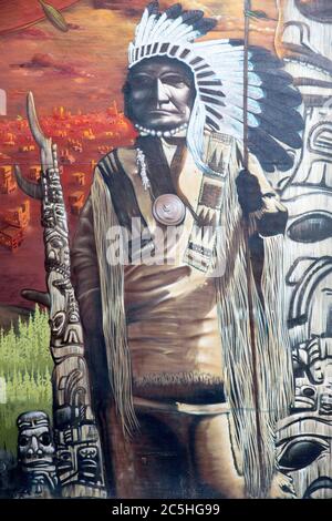 MONTREAL CANADÁ AGOSTO 21 2014: Arte callejero y graffiti. Retrato exterior de un jefe nativo americano con lanza, con tótem en el fondo.