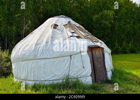 Yurt nómada en un bosque de claro al atardecer. Estructura de vivienda doblada portátil utilizada tradicionalmente por los nómadas en las estepas de Asia Central. Foto de stock