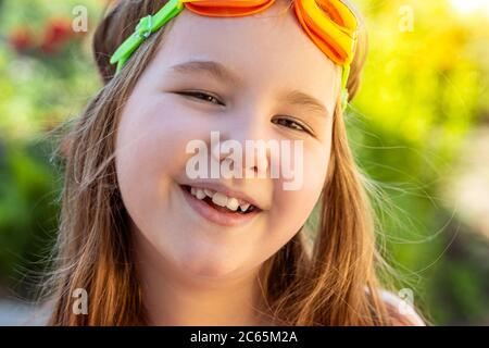 Retrato de una hermosa niña con gafas para la piscina. Actividades con niños al aire libre. Verano divertido. Espacio de copia.