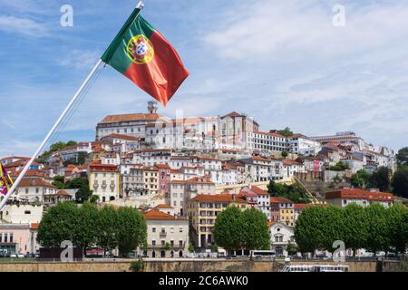 Coimbra, Portugal - 11 de noviembre de 2018: Bandera nacional portuguesa que se balancea sobre la ciudad vieja de Coimbra. Coimbra tiene una de las universidades más antiguas de Europ Foto de stock