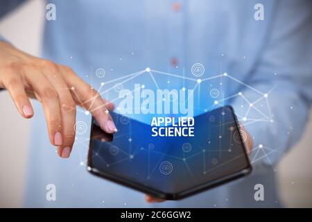 Empresario sosteniendo un smartphone plegable con inscripción de ciencia aplicada, la nueva tecnología concepto